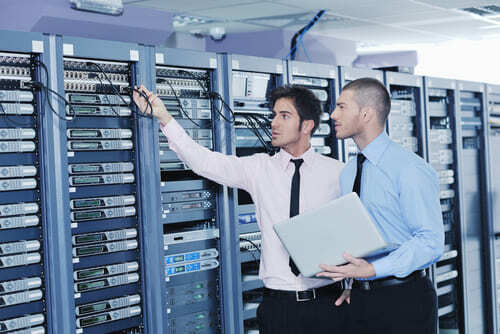 two computer systems analysts inspect data storage facility